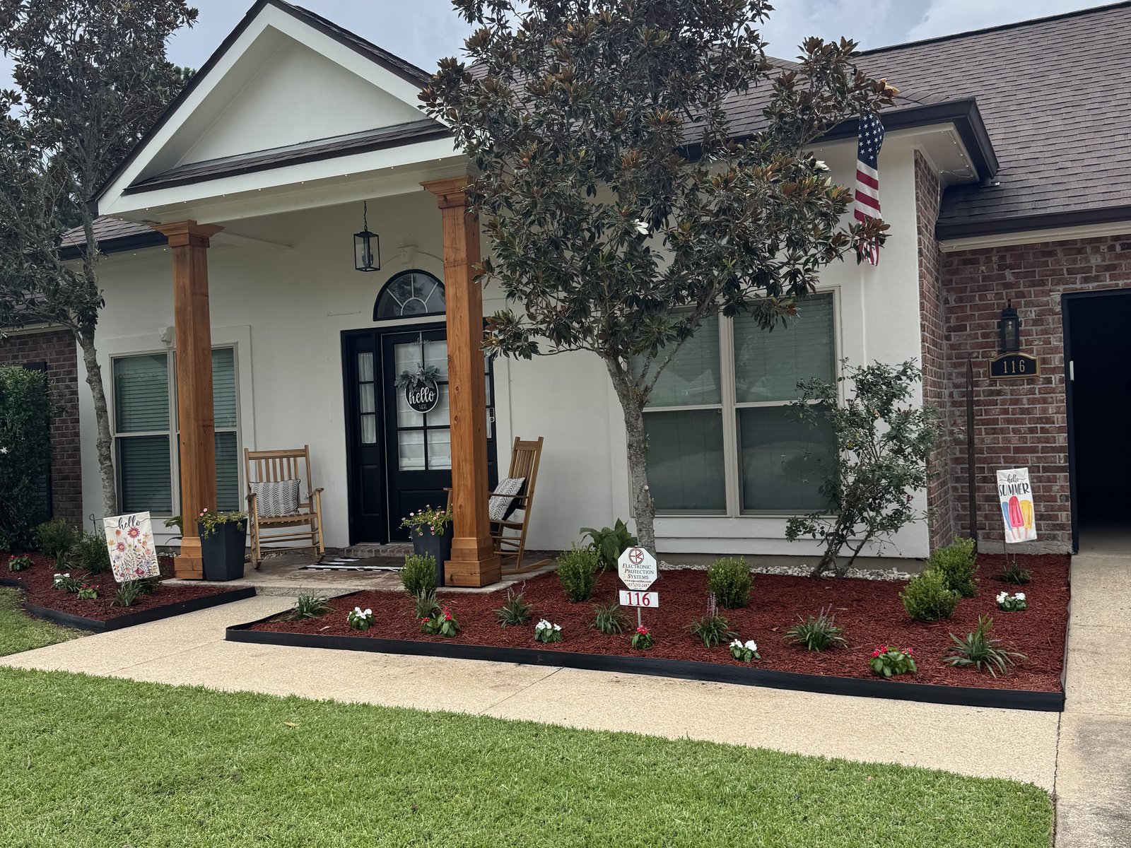 Front-entry beds with fresh red mulch, new plantings, and crisp edging